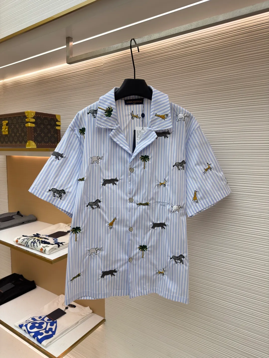 LOUIS VUITTON nostalgic style embroidered striped short-sleeved shirt with animals and plants ●Original version: Purchased and developed by 16815 ●Item number: 1682514-A65 ●Fabric: cotton fabric ●Technology: embroidery production ●Color: blue ●Version: fitted version ●Weight: about 220 grams ●Size: S-M-L-XL ●Description: This LOUIS VUITTON striped animal embroidery short-sleeved shirt is made of high-count pure cotton poplin fabric. After pre-washing process, it feels smooth and breathable. It has both drape and stiffness, and is not easy to wrinkle and deform. The blue and white vertical stripes on the body are woven with yarn-dyed technology, and the texture is clear and does not fade. The animal and coconut tree patterns are presented with sophisticated embroidery technology. The embroidery threads are full of color and the stitches are dense. The patterns are three-dimensional and vivid, forming a rich visual hierarchy with the stripe base. The shirt has a Cuban collar style, with smooth necklines, custom mother-of-pearl buttons at the placket, and a warm texture. The overall shape is loose, the shoulder joints are straight and fine, the cuffs are cuffed with exquisite craftsmanship, custom accessories and three logos are complete, and the details are full of luxury craftsmanship. It is suitable for casual vacations and daily outings, etc. The overall wiring is straight and delicate, the fabric is comfortable and soft, and the color is consistent without color difference. It can be matched with the same style to create a fashionable look and control various occasions. Customized accessories, complete with three standards, same style for men and women!